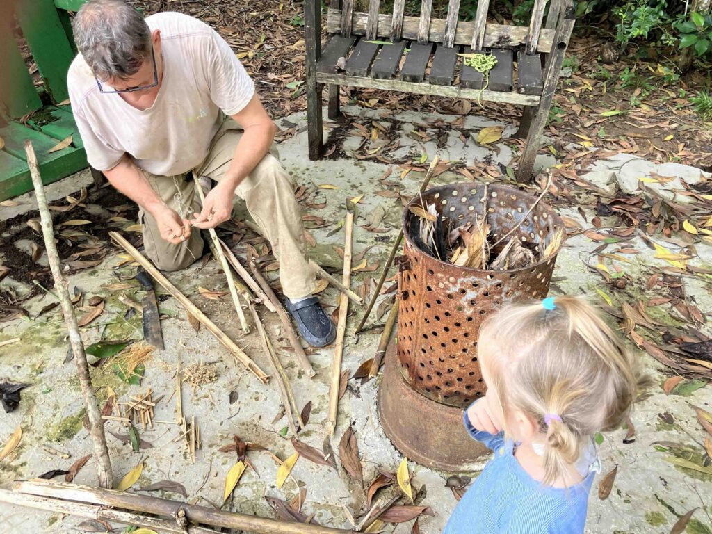 Howard showing how to make fire with bamboo sticks